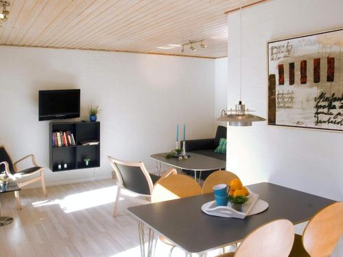 a living room with tables and chairs and a tv at 4 person holiday home in Allinge in Allinge