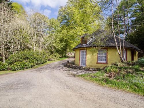 a small yellow house on a dirt road at Tinkerbell in Balnaboth
