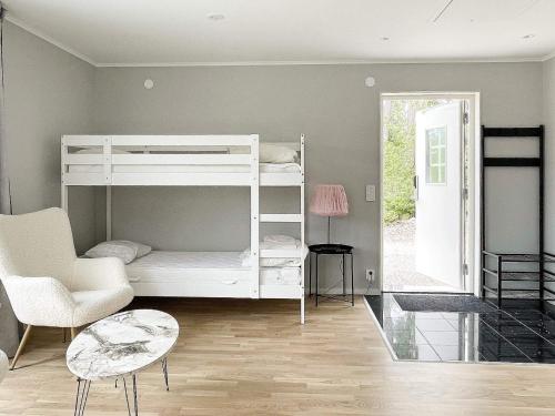 a bedroom with a white bunk bed and a chair at 4 star holiday home in Klintehamn in Klintehamn