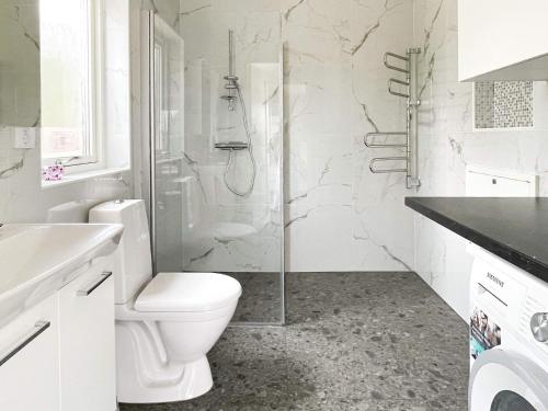 a white bathroom with a shower and a toilet at 4 star holiday home in Klintehamn in Klintehamn