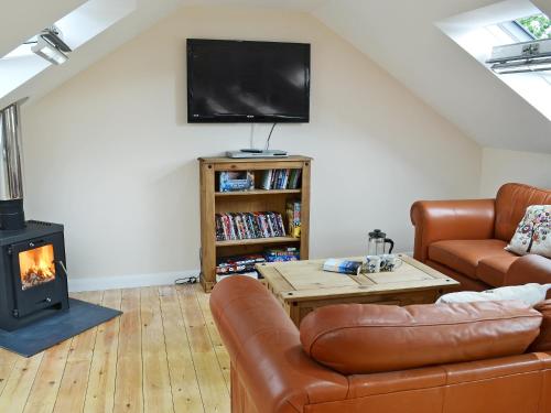 a living room with a couch and a fireplace at Stonechat Barn in Pancrasweek