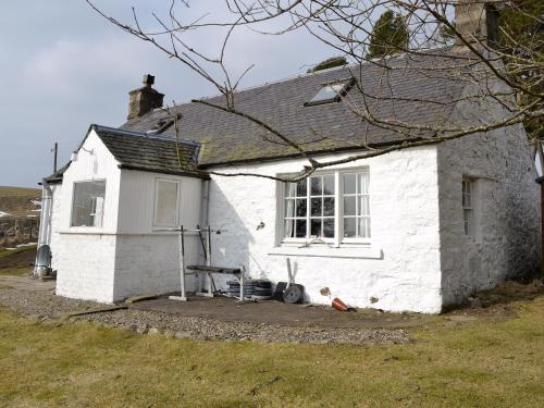 a white house with a window and a bench outside at Buckhood - Swwy in Inchmill