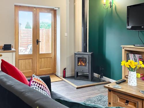 a living room with a couch and a fireplace at Nuthatch Barn in Pancrasweek