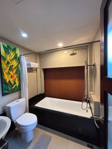 a bathroom with a tub and a toilet and a sink at Sari Villa Ubud in Ubud