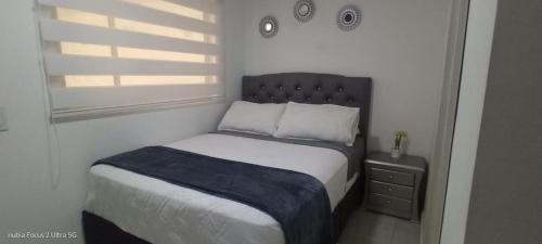 a small bedroom with a bed and a window at Room cerca al aeropuerto #5 in Bogotá