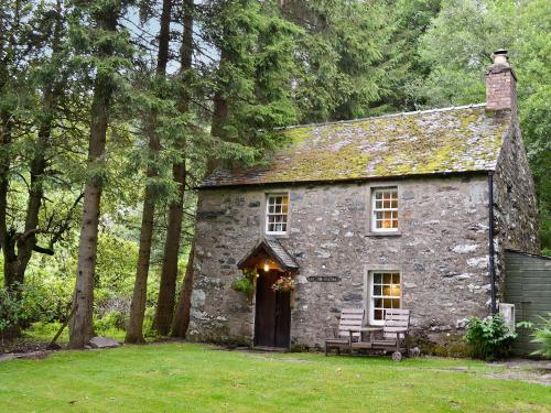 an old stone house in the middle of a yard at Gardener's Bothy in Balnaboth