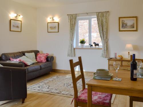 a living room with a couch and a table at Bess's Cottage in Middlewich