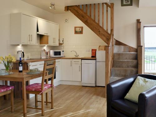 a kitchen and living room with a table and chairs at Bess's Cottage in Middlewich