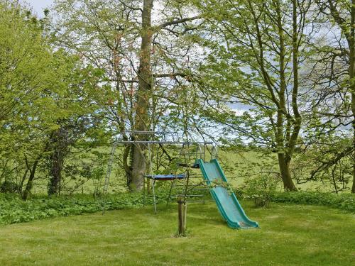 a blue slide in the middle of a park at Fairlaw Garden Cottage in Reston