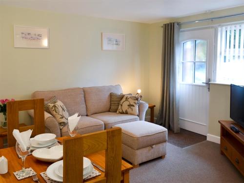 a living room with a couch and a table at Bluebell in Saint Ewe