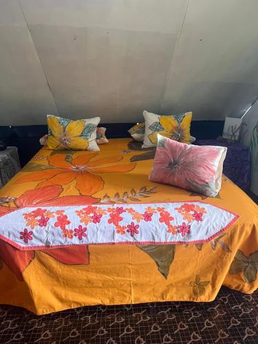 a large bed with pillows on top of it at Chalet Avapeihi in Fitii