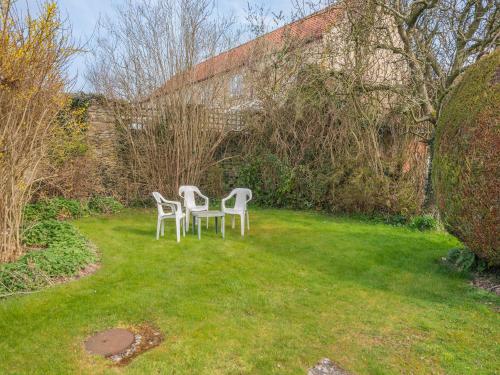 two white chairs sitting in the grass in a yard at Peartree Farm Cottages - Rchm39 in Ebberston