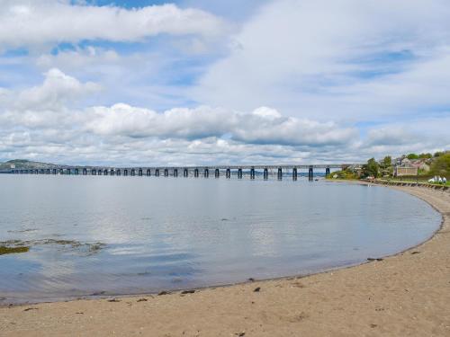 a large body of water with a pier in the distance at Glentairre Cottage - Swww in Balnaboth