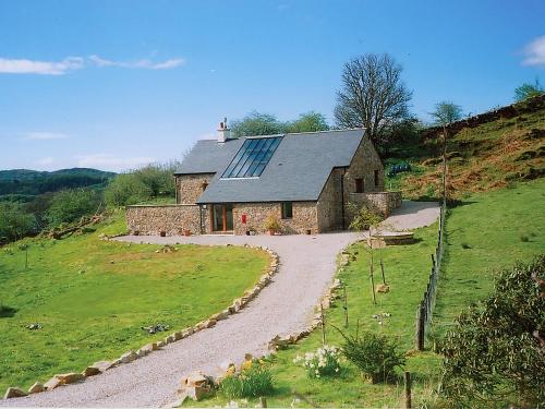 a stone house on a hill with a gravel road at Achabeg - S4597 in Taynish