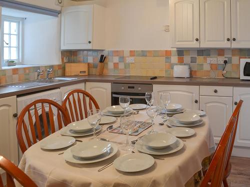 a kitchen with a table with plates and wine glasses at Purlinney in Treknow
