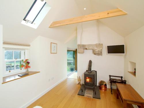 a living room with a wood stove in it at Tullibole Castle Longhouse in Crook of Devon