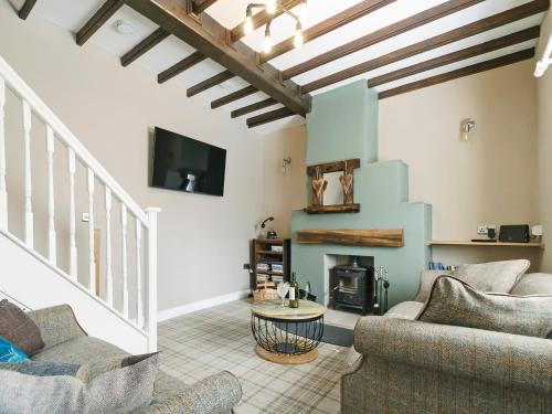a living room with two couches and a fireplace at Pinfold Cottage in Richmond