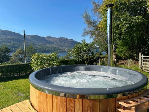 a hot tub with a water fountain in a yard at Tigh-Na-Creige in Feorlean