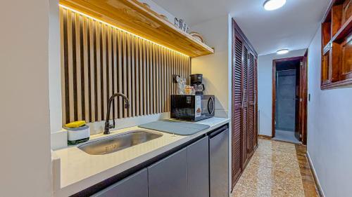 a kitchen with a sink and a microwave at Primavera Lofts in Medellín