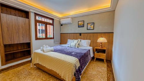 a bedroom with a bed and a lamp on a table at Primavera Lofts in Medellín