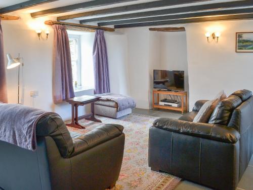 a living room with two leather couches and a television at Culvada in Treknow