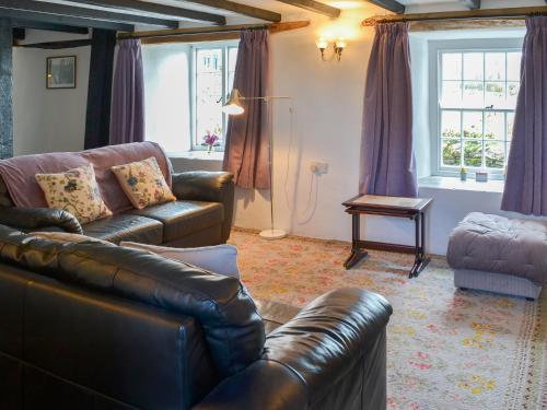 a living room with a leather couch and a table at Culvada in Treknow
