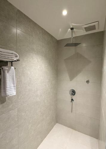 a bathroom with a shower with a glass door at فندق فاليرا باي - محايل عسير VALERA BAY Hotel in Muhayil