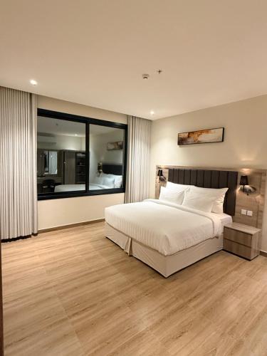 a bedroom with a large bed and a large window at فندق فاليرا باي - محايل عسير VALERA BAY Hotel in Muhayil