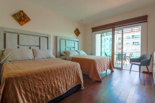 a hotel room with two beds and a balcony at Pacifika in Mazatlán