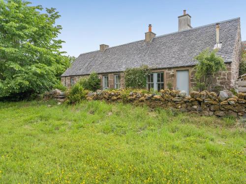 an old stone house with a stone wall at The Cottage in Bankfoot