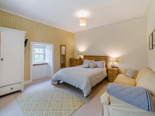 a bedroom with a bed and a couch at The Cottage in Bankfoot