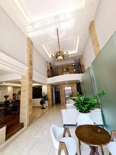 a lobby with a table and chairs and a chandelier at GreenStay Hotel & Apartment in Ho Chi Minh City
