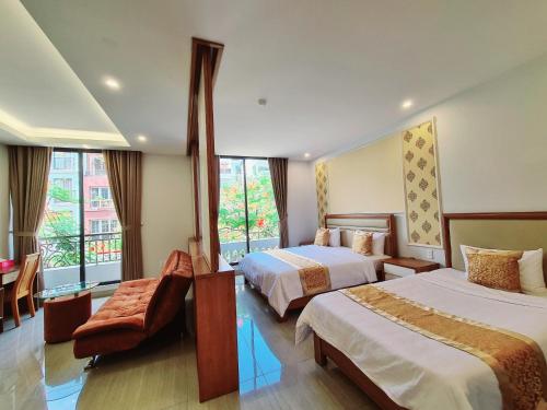 a hotel room with two beds and a window at GreenStay Hotel & Apartment in Ho Chi Minh City