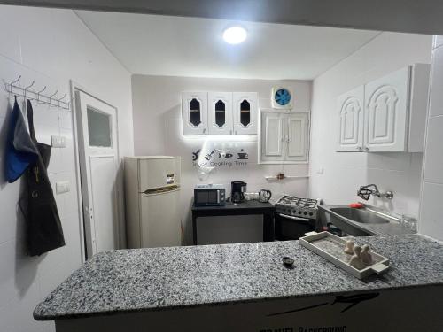 a kitchen with white cabinets and a counter top at Backpackers Room 3 in Naj‘ al Maḩaţţah