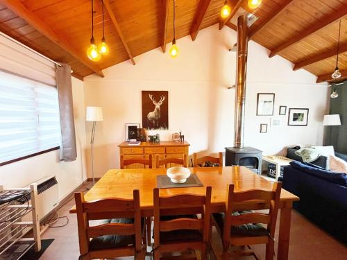 a dining room with a wooden table and chairs at Cozy chalet for 6 people in Rendeux