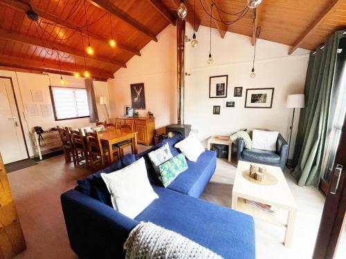 a living room with a blue couch and a table at Cozy chalet for 6 people in Rendeux