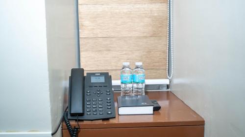 two bottles of water and a telephone on a desk at Emmie Hotel in Legazpi