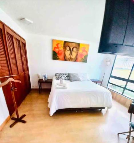 a bedroom with a bed and a painting on the wall at Ultimate Whole Floor Apartment in Bogotá