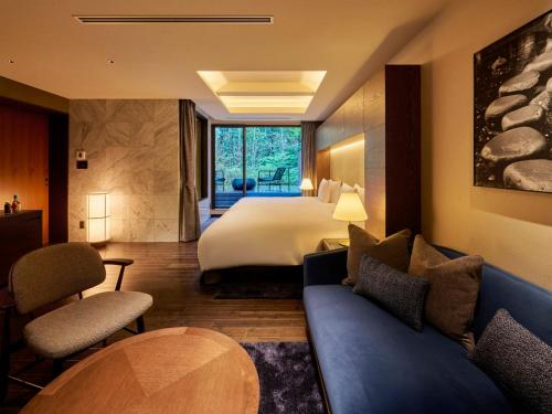 a hotel room with a bed and a couch at Hakone Suishoen in Hakone