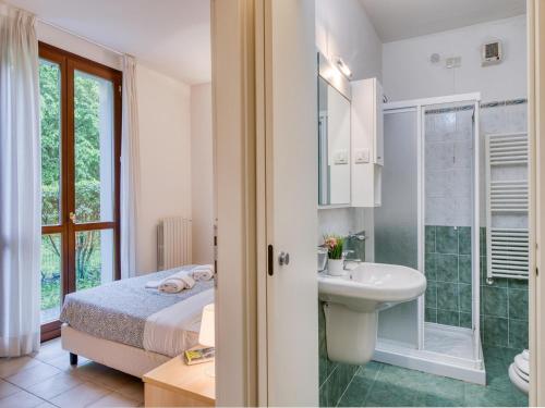a bedroom with a bed and a sink and a shower at Mobilehome am Luganersee in Porlezza