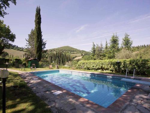 a swimming pool in the yard of a house at Pretty farmhouse with terrace in Radda in Chianti