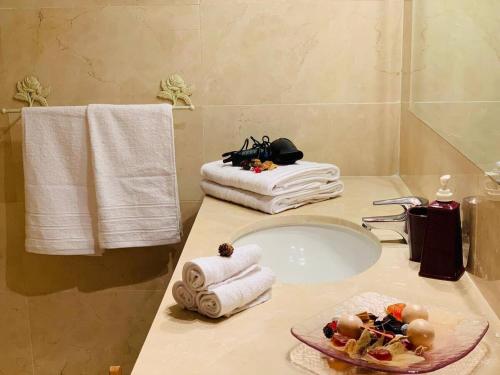 a bathroom sink with towels and a plate of food on it at Spectacular beachfront apartment in Estepona