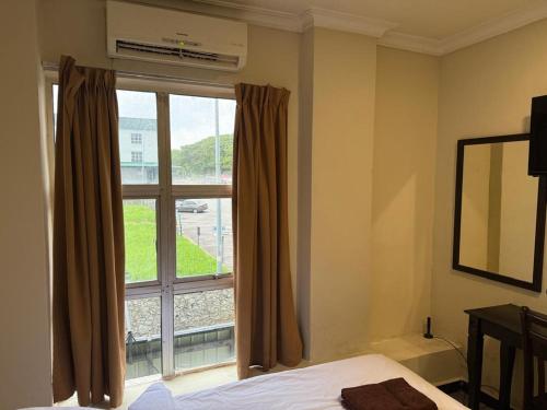 a bedroom with a bed and a large window at Jam Hotel Nilai in Nilai
