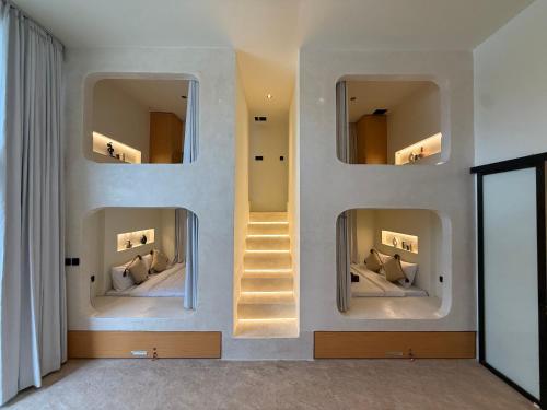 a room with three mirrors on a wall with a staircase at Soma House - Adults Only in Kuta Lombok