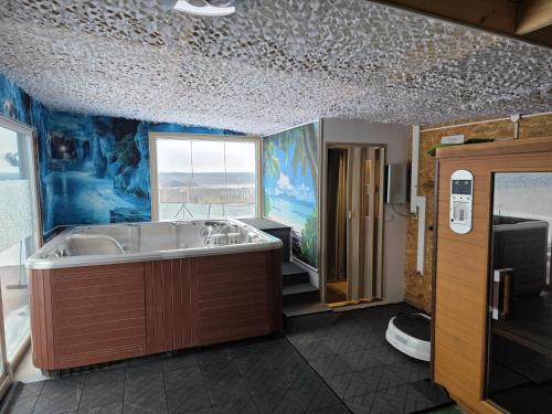 a bathroom with a large tub and a large window at Comfortable holiday home, pool, sauna, jacuzzi in Brzuze