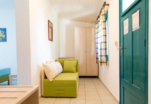 a green chair in a hallway with a door at Angeliki Beach Hotel in Megali Ammos