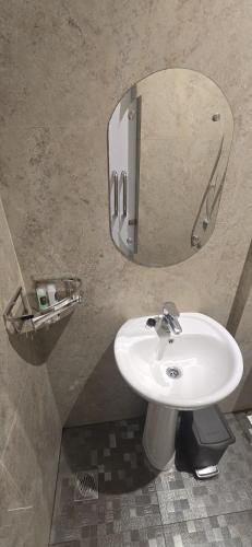 a bathroom with a white sink and a mirror at Da Rucci Hotel syariah in Medan