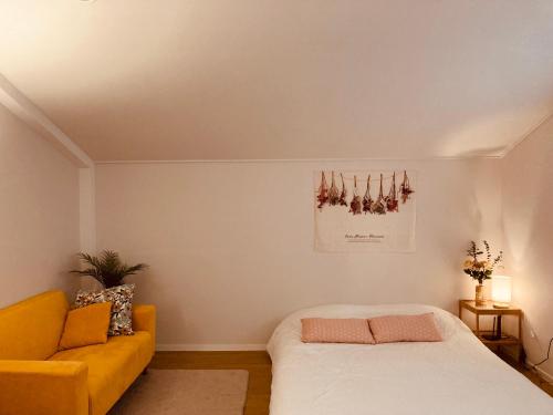a bedroom with a bed and a yellow couch at Dontan terrace in Hwaseong