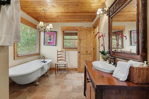 a bathroom with a tub and a large mirror at Vintage Luxury Mountain Cabin, Creekside, King Bed, Spa, Fire Pit, Game Room, DogsOk in Hiawassee