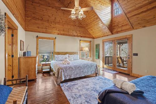 a bedroom with two beds and a wooden ceiling at Vintage Luxury Mountain Cabin, Creekside, King Bed, Spa, Fire Pit, Game Room, DogsOk in Hiawassee